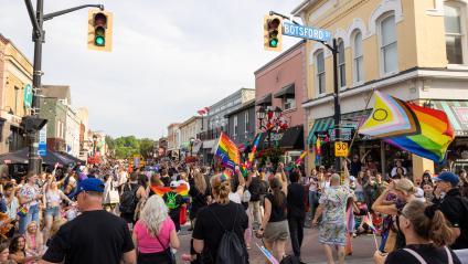 York Pride Festival parade, large crowd walking South down Main Street and Botsford Street